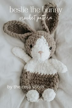 a crocheted bunny laying on top of a white bed with the words, bestie the bunny crochet pattern by the cozy stitch