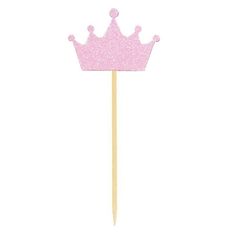 a pink cake topper sitting on top of a wooden stick with a crown on it