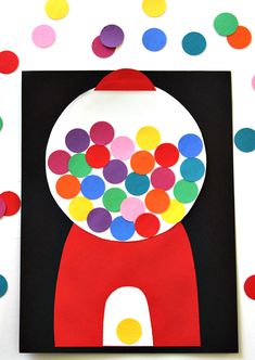 a paper plate with colorful circles and a gummy machine on it, surrounded by confetti