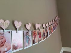 a baby's first birthday banner with photos and hearts hanging on the wall next to stairs