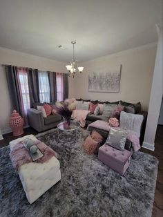 a living room filled with lots of furniture next to a large rug on top of a hard wood floor