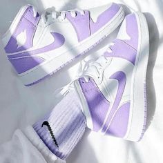 a pair of purple and white nike sneakers