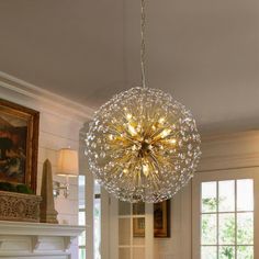 a chandelier hanging from the ceiling in a living room with fireplace and windows