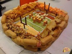 a football stadium cake with chips and dips on it, ready to be eaten