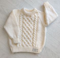 a white sweater and hat laying on top of a table