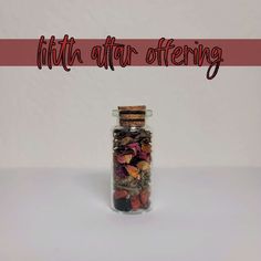 a glass jar filled with lots of different types of items next to the words little altar offering