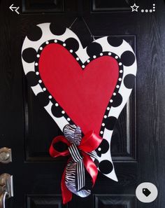 a heart shaped door hanger on a black door with red and white polka dots