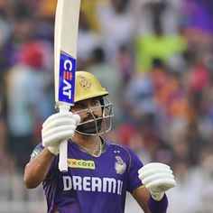 a man holding a bat in his hand and wearing a helmet on top of it