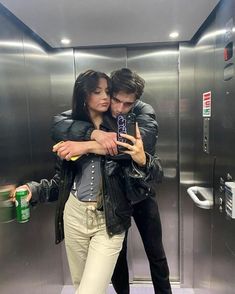 a man and woman are hugging in an elevator