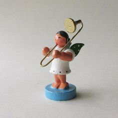 a small figurine holding a brass trombone