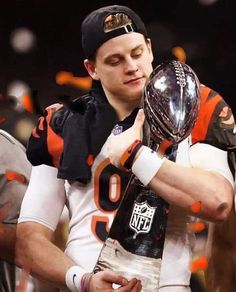 a football player holding the trophy in his hands