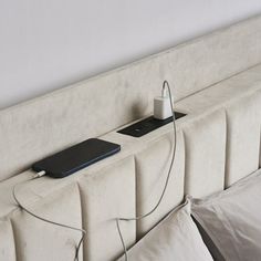 a white headboard with an electronic device plugged into it