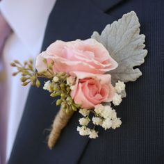 a boutonniere with pink roses and baby's breath is worn on the lapel of a man