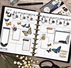 an open planner with lots of butterflies on it next to some scissors and other items