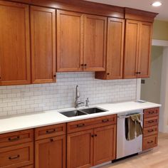 a kitchen with wooden cabinets and white counter tops