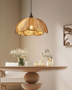 a table with flowers and candles on it under a light fixture in a living room