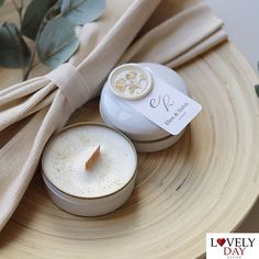 a small candle sitting on top of a wooden table next to a tag with the word lovely day written on it