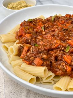 a white bowl filled with pasta and meat sauce