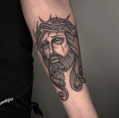 a man's arm with a tattoo of jesus on it