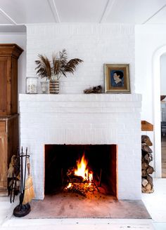 a fire place in a living room with white brick and wood burning inside the fireplace