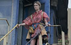 a woman dressed as a pirate standing on steps with a large metal pole in her hand