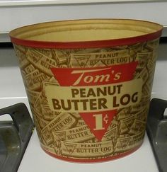 an old tom's peanut butter log bucket sitting on top of a stovetop