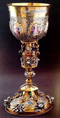 an ornately decorated gold goblet with pictures on it