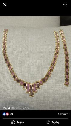 a pink and gold necklace on a white pillow