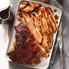 barbecue ribs and sauce on a plate with utensils