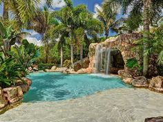 a pool with waterfall and palm trees surrounding it