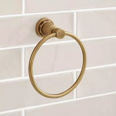 a gold towel ring on a white tiled wall