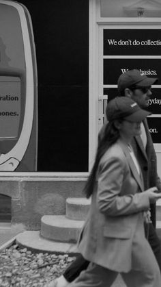 a woman walking down the street in front of a store