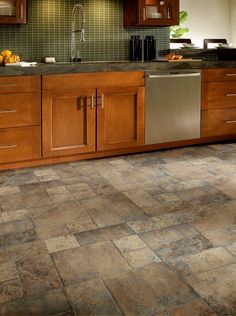 a kitchen with wood cabinets and tile flooring