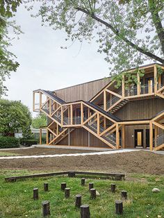 a large wooden building with stairs leading up to it's second story and two stories