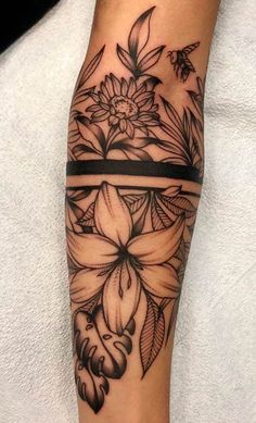 a black and white tattoo with flowers on it