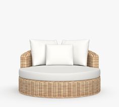 a wicker couch with white pillows on it