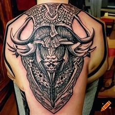 the back of a man's shoulder with an animal head and horns on it