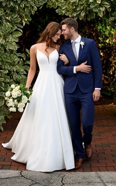 a bride and groom are standing in front of some greenery at their wedding day