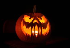 a carved pumpkin with an evil face on it's face and eyes lit up in the dark