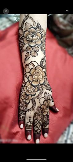 a woman's hand is decorated with hennap and flower designs on it