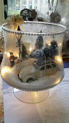 a glass bowl filled with christmas decorations on top of a table