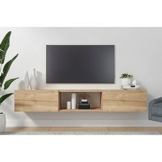 a flat screen tv mounted to the side of a wooden entertainment center in a living room