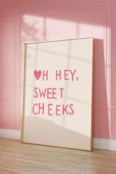 a pink room with a framed poster saying oh hey, sweet cheeks