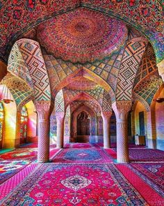 the inside of an ornate building with many colorful carpets and arches, all covered in intricate designs