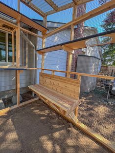 a wooden bench sitting inside of a chicken coop