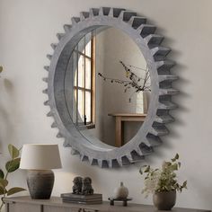 a mirror that is sitting on top of a dresser next to a vase and lamp