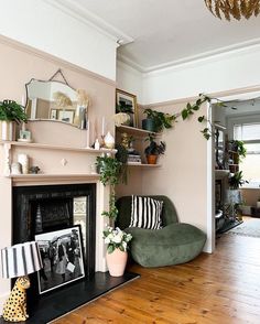 a living room filled with furniture and a fire place covered in plants on top of a hard wood floor