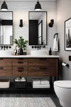 a bathroom with two sinks and three mirrors on the wall next to a white toilet