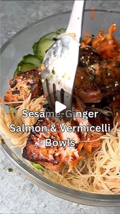 a glass bowl filled with pasta, meat and veggies next to a fork