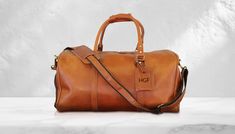 "Personalized Leather Duffle Bag - Custom Travel Weekend Bag - Handcrafted Luxury DETAILS - %100 Cowhide Leather - Best Zipper Brand of YKK Used in The Bags  - Handmade COLORS - Black  - Dark Brown - Light Brown SIZES - Small Size: 14\" - 10 - 10\" inches - X-Large Size: 21\" - 11\" - 11\" inches PERSONALIZATION We can engrave initials, name and logo to the luggage tag attach to the bag. We just have letters A - Z a-z, numbers 0-9 and characters: & and ❤️ Initials: Max. 4 Characters Names: Max. Classic Brown Bag With Engraved Logo, Classic Brown Bags With Engraved Logo, Brown Leather Bags With Engraved Logo, Brown Travel Bags With Engraved Logo, Brown Bags With Engraved Logo For Daily Use, Luxury Details, 4 Characters, Leather Toiletry Bag, Engraved Initials